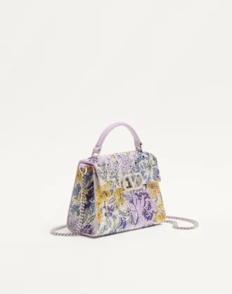 Mini sac à main Valentino Garavani Vsling avec motif Flowerism en strass et logo bijou