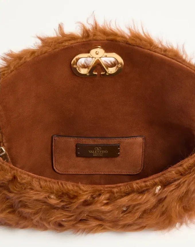 Petit sac à bandoulière Valentino Garavani DeVain en fourrure d’agneau avec strass. Petit sac à bandoulière Valentino Garavani DeVain en fourrure d’agneau avec strass.