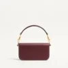 Petit sac à bandoulière Valentino Garavani Locò en cuir de veau avec logo bijou Petit sac à bandoulière Valentino Garavani Locò en cuir de veau avec logo bijou