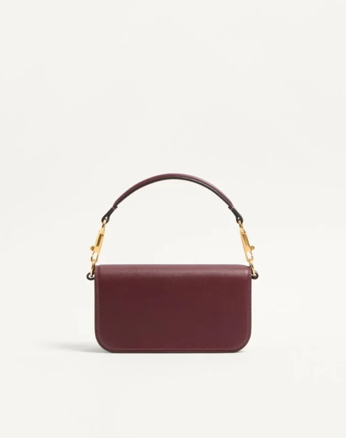 Petit sac à bandoulière Valentino Garavani Locò en cuir de veau avec logo bijou Petit sac à bandoulière Valentino Garavani Locò en cuir de veau avec logo bijou