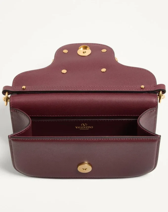 Petit sac à bandoulière Valentino Garavani Locò en cuir de veau avec logo bijou Petit sac à bandoulière Valentino Garavani Locò en cuir de veau avec logo bijou