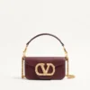 Petit sac à bandoulière Valentino Garavani Locò en cuir de veau avec logo bijou Petit sac à bandoulière Valentino Garavani Locò en cuir de veau avec logo bijou
