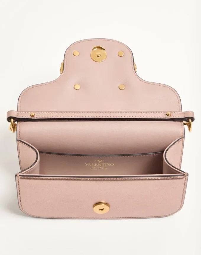Petit sac à bandoulière Valentino Garavani Locò en cuir de veau laminé avec logo bijou Petit sac à bandoulière Valentino Garavani Locò en cuir de veau laminé avec logo bijou