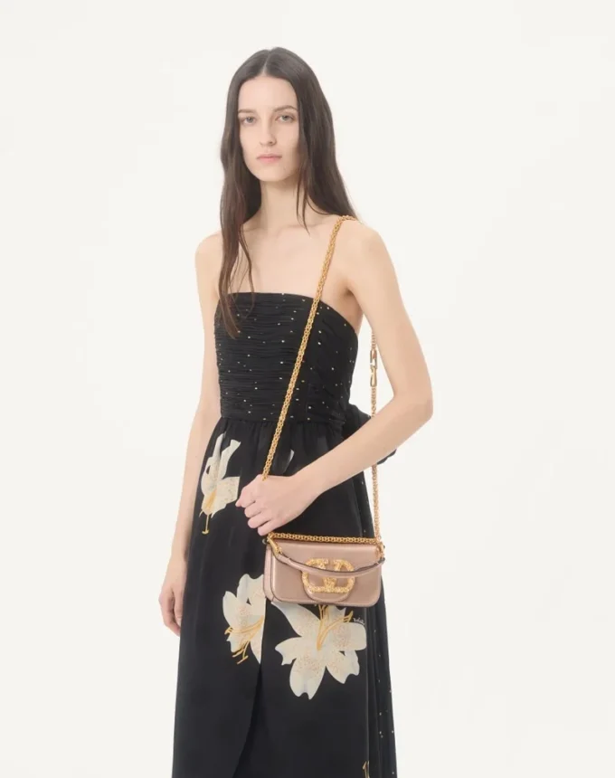 Petit sac à bandoulière Valentino Garavani Locò en cuir de veau laminé avec logo bijou Petit sac à bandoulière Valentino Garavani Locò en cuir de veau laminé avec logo bijou