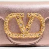 Petit sac à bandoulière Valentino Garavani Locò en cuir de veau laminé avec logo bijou Petit sac à bandoulière Valentino Garavani Locò en cuir de veau laminé avec logo bijou