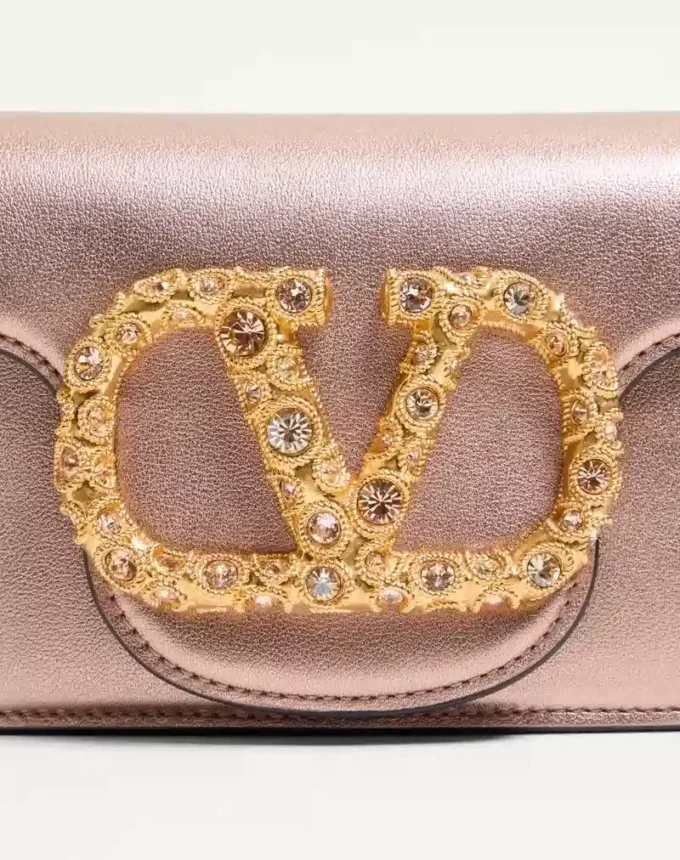 Petit sac à bandoulière Valentino Garavani Locò en cuir de veau laminé avec logo bijou Petit sac à bandoulière Valentino Garavani Locò en cuir de veau laminé avec logo bijou
