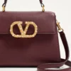 Petit sac à main Valentino Garavani Vsling en cuir de veau grainé avec logo bijou Petit sac à main Valentino Garavani Vsling en cuir de veau grainé avec logo bijou