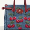 Petit sac shopping Valentino Garavani Antibes en denim avec broderie Cherryfic Petit sac shopping Valentino Garavani Antibes en denim avec broderie Cherryfic